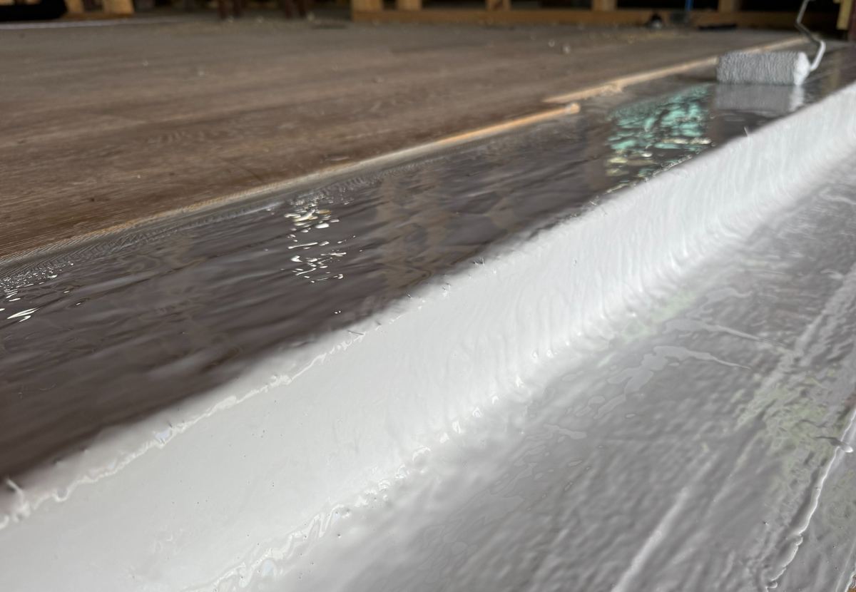 Close-up of fluid-applied membrane turned up at the deck-to-wall coping