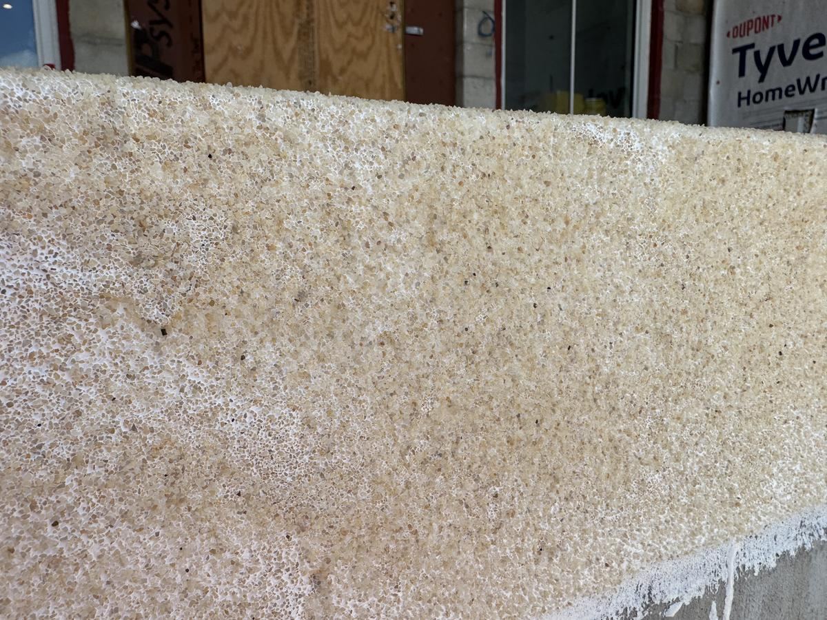 Broadcast quartz aggregate texture detail on coated deck coping