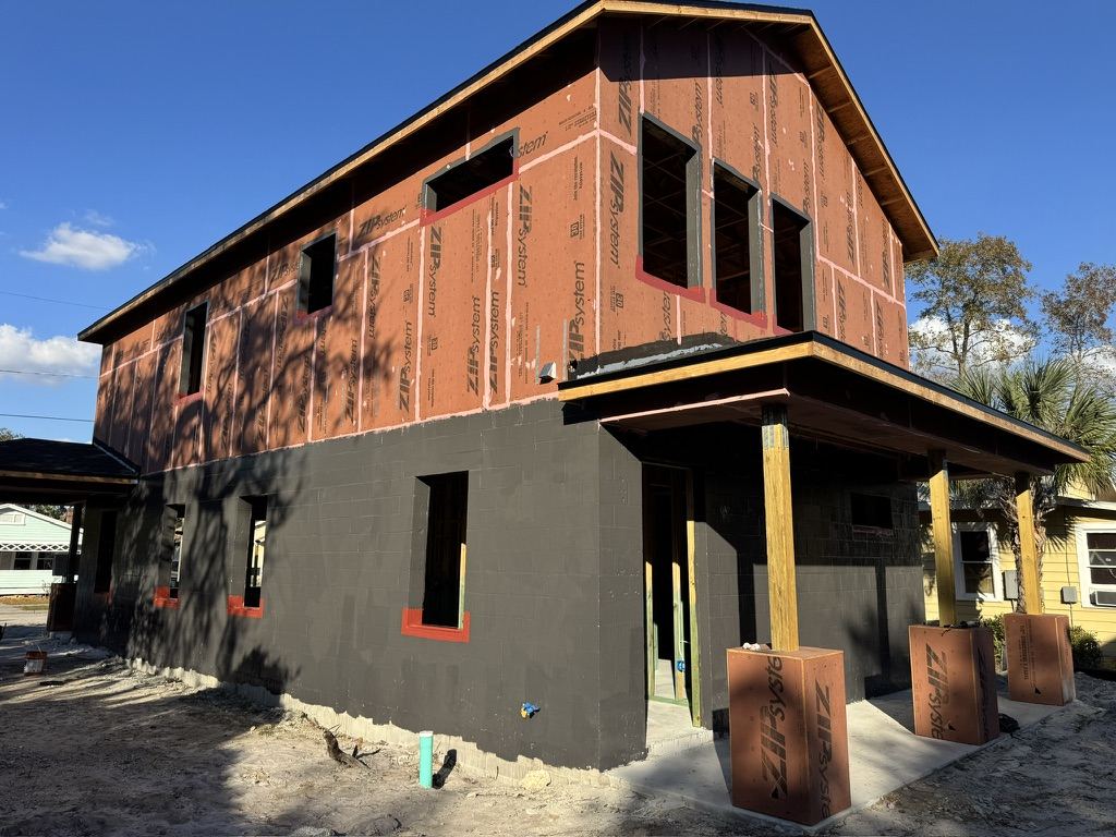 Fluid-applied air and water barrier on a two-story wood-framed residence