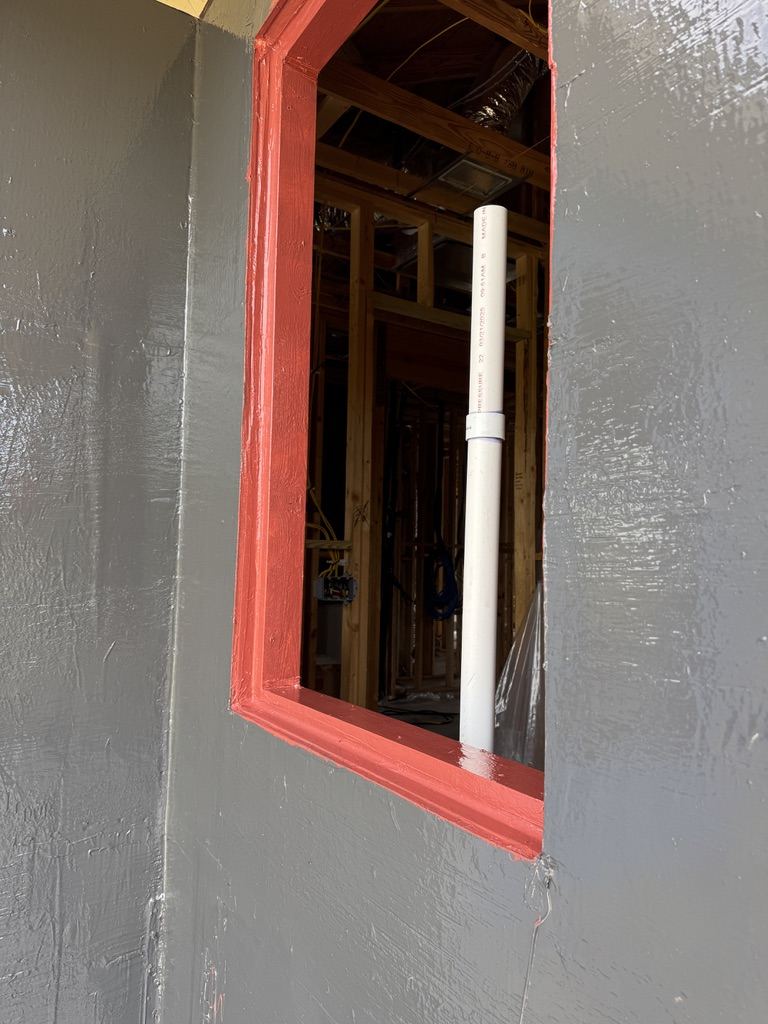 Window rough opening waterproofed with liquid flashing at the jambs and sill