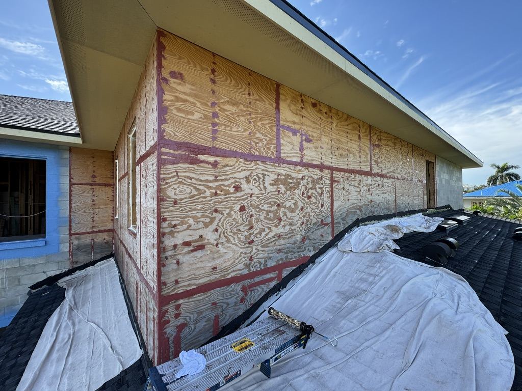 Air barrier and liquid flashing applied over sheathing on a single-story residence