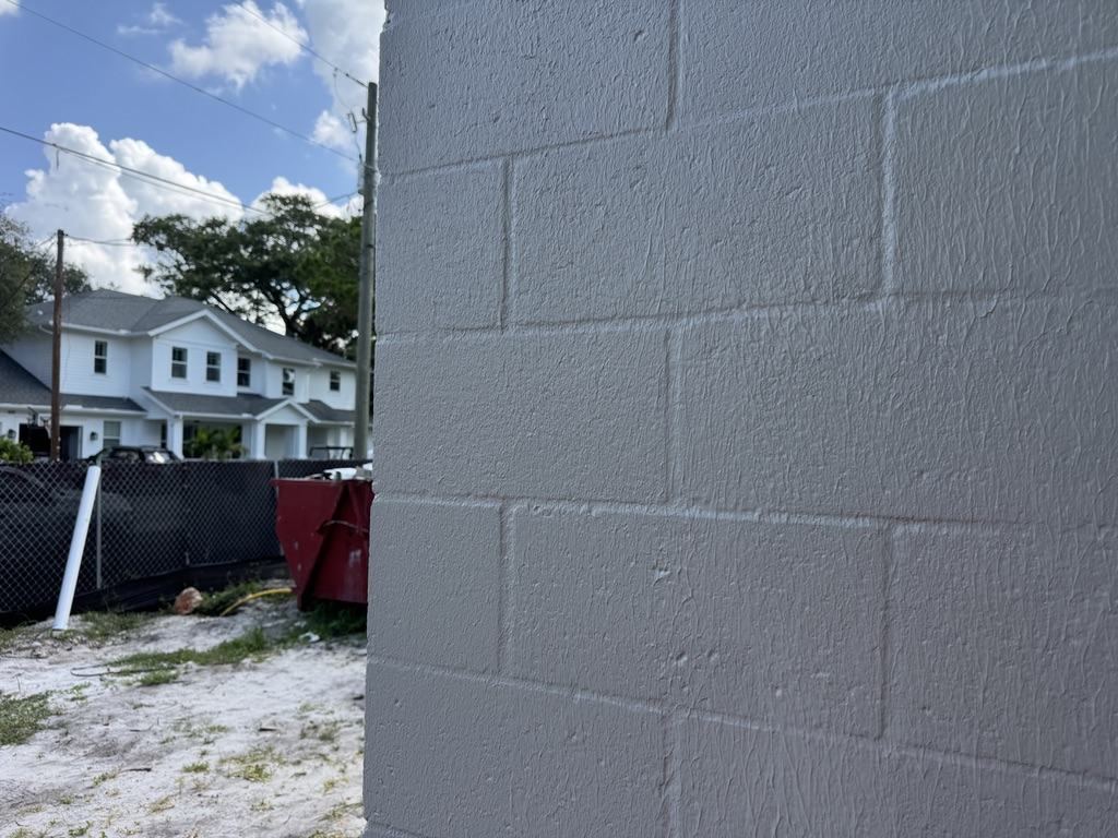 Close-up of fluid-applied air and water barrier over CMU, fully bridging block faces and mortar joints