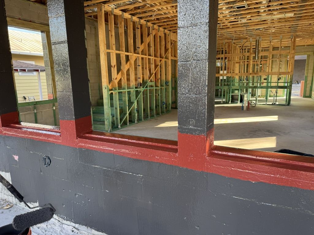 Interior CMU walls with barrier coating and liquid flashing at the slab edge