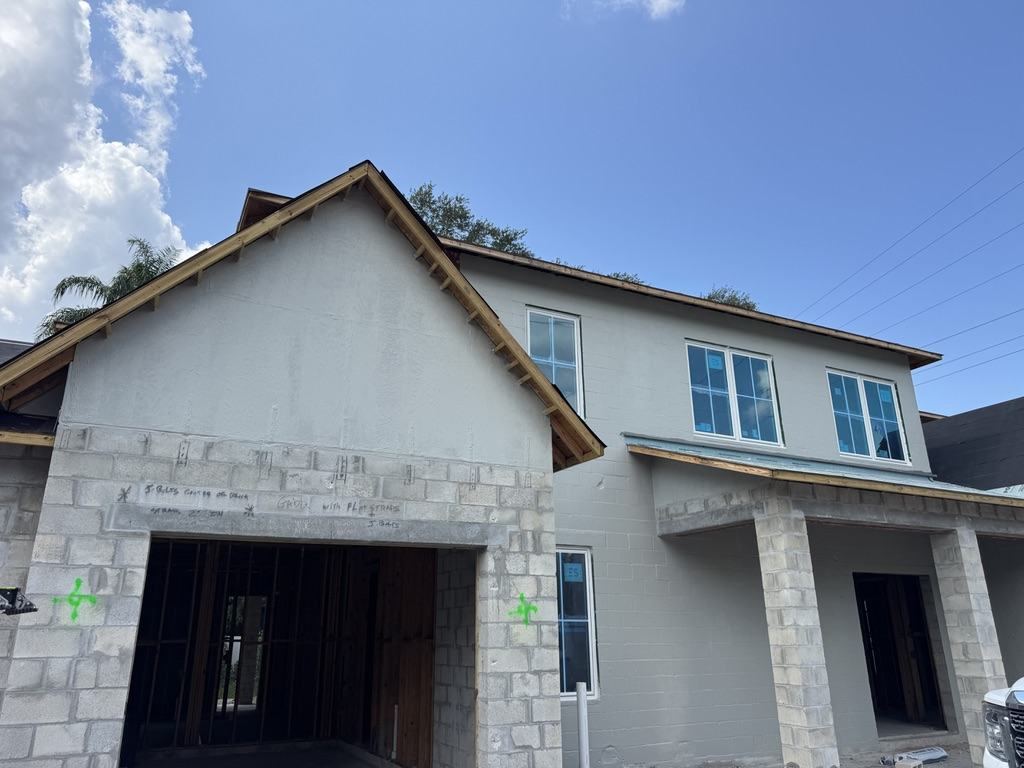 Air and water barrier applied to the upper walls and gable end of a two-story CMU residence