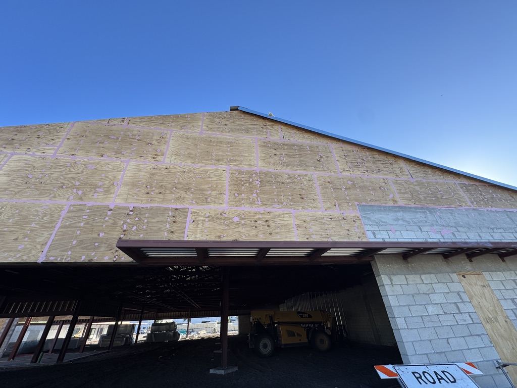 Continuous air barrier across a sloped roof and wall assembly