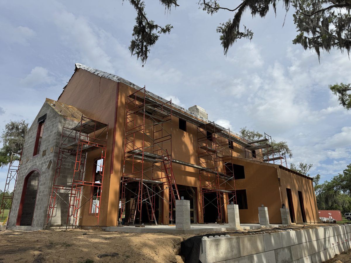 Two-story residence with continuous barrier over sheathing and CMU