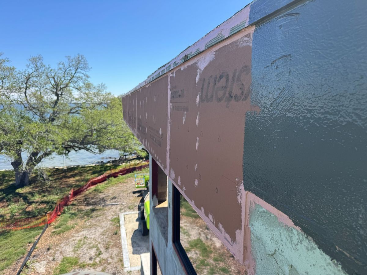 Fluid-applied air and water barrier on an exterior wall elevation